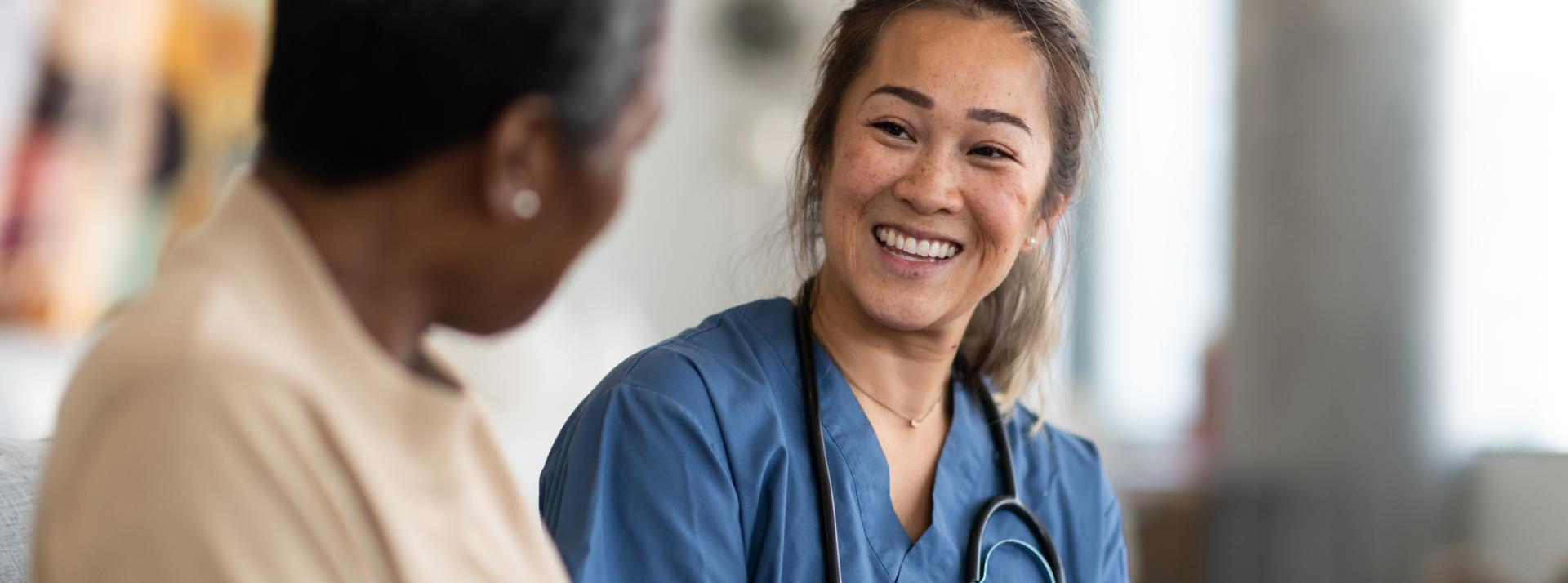 Smiling doctor speaking with patient while reviewing informatio on a clipboard