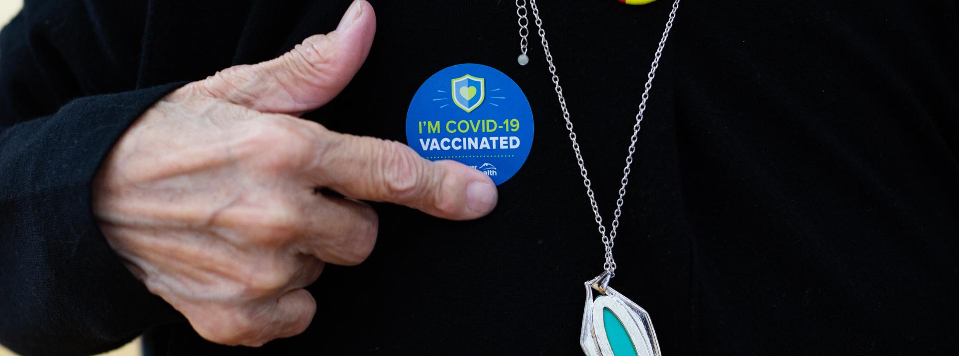 person with covid vaccine sticker