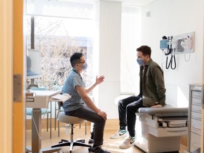 Health professional talking to patient in an exam room.