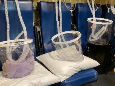 Inside of a Hyperbaric chamber with 3 blue seats in a row with tubes and oxygen masks