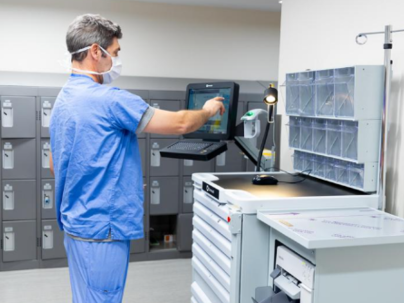 A doctor at a workstation typing on a computer screen
