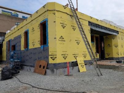 A building under construction with yellow walls and a ladder