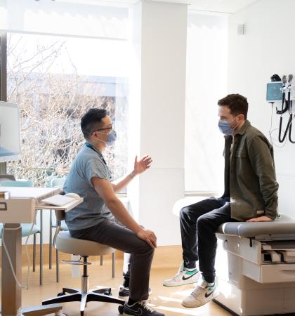 Health professional talking to patient in an exam room.