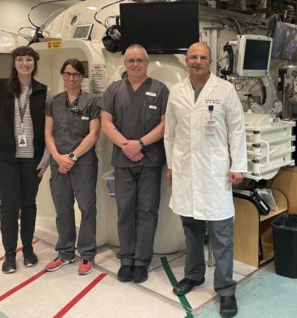 medical team standing in a medical room in from of a large hyperbaric chamber unit