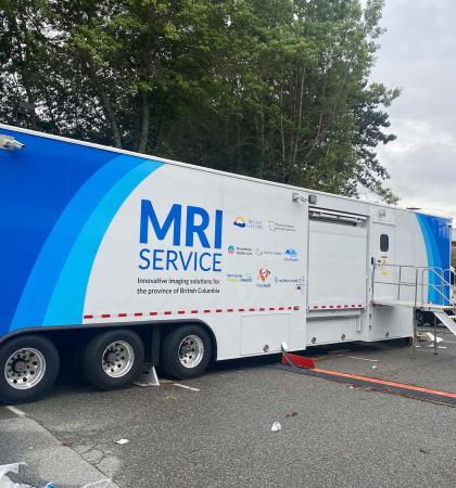 A large trailer in a parking lot that contains a mobile MRI machine